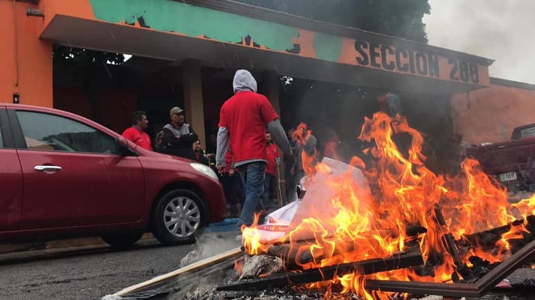 Más de un centenar de obreros 'napistas' derribaron la reja del edificio sindical.