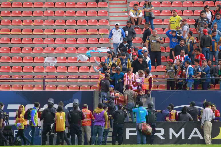 Algunos aficionados bajaron al campo para protegerse. (Jam Media)