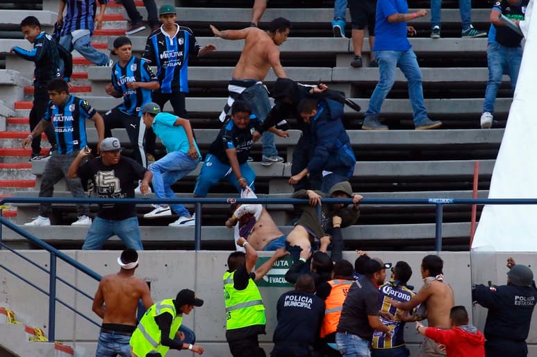 Aficionados queretanos golpean a un hincha rival durante el partido que enfrentó al Atlético de San Luis y los Gallos Blancos. (JAM MEDIA)