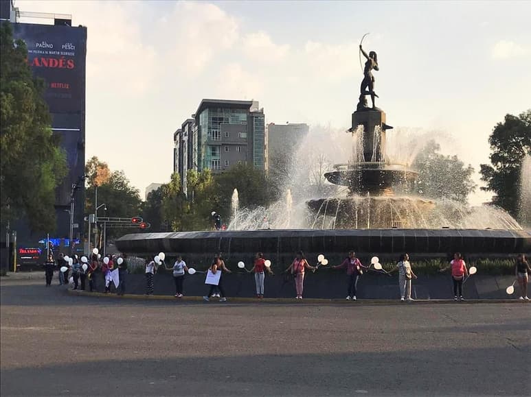 Con globos blancos y listones de color violeta en sus manos, las mujeres se fueron colocando tomadas de las manos alrededor de la Diana Cazadora, mismo que fue escogido por tratarse de una mujer. (ESPECIAL)