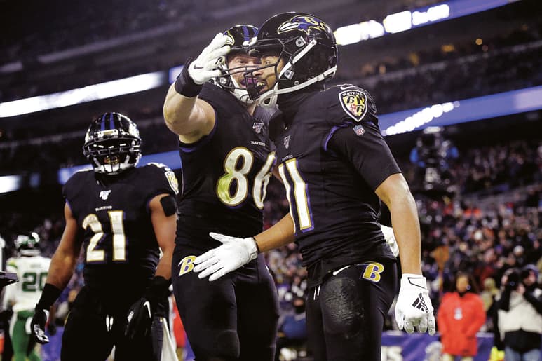El receptor Seth Roberts (11) festeja con Nick Boyle (86)y Mark Ingram (21) tras anotar en el duelo de Jueves por la Noche. (AP)