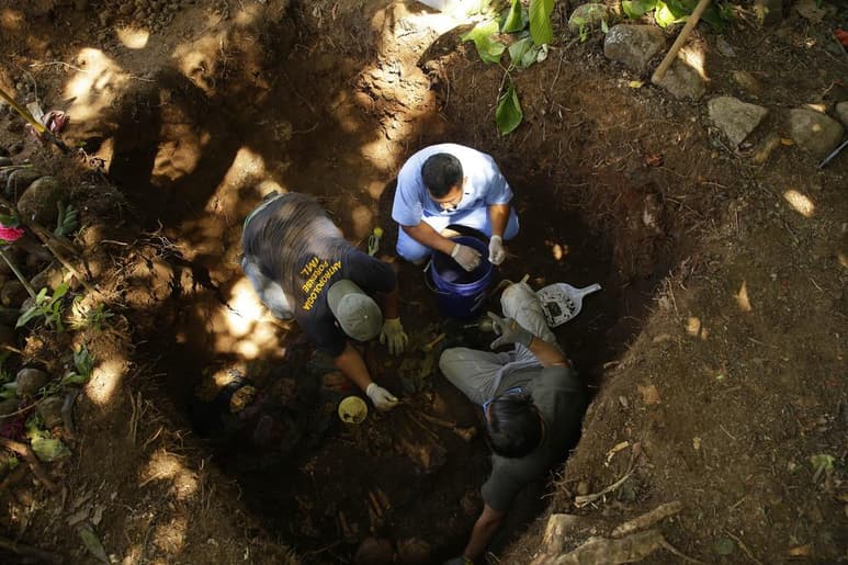 Antropólogos forenses durante la exhumación de restos humanos, víctimas de la matanza de El Mozote. (ARCHIVO)