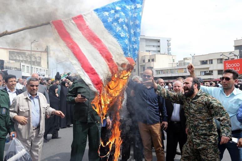 Cerca de la casa donde vivió el ayatola Ruhollah Jomeini, los obreros de una pequeña fábrica hacen banderas americanas para que sena vendidas y quemadas. (ARCHIVO)