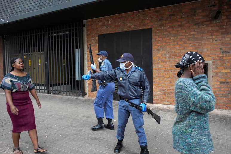 Policía de Sudáfrica da indicaciones sobre distanciamiento social a un grupo de mujeres. (EFE)