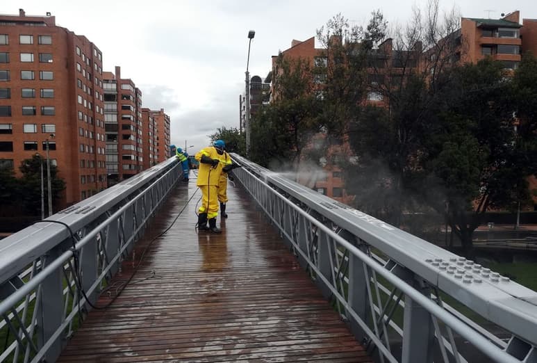 Trabajadores de la limpieza del Distrito Capital desinfectan un puente en el norte de la ciudad de Bogotá. (EFE)