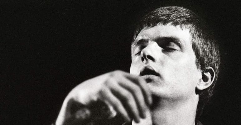 Un día antes de marcharse de gira a Estados Unidos, Ian Curtis se suicidó. Se ahorcó en la cocina de su casa. Se colgó de un tendedero mientras en su tocadiscos sonaba Iggy Pop. Puso fin a Joy Division y creó un mito romántico en torno a él. Murió la persona, nació la leyenda. (ESPECIAL)