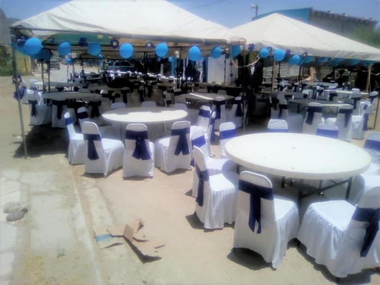 La celebración de los XV años se esperaba realizarla en plena calle y ya se habían colocado flores, toldos, globos y la mantelería en color azul y blanco además de una lona con la fotografía de la quinceañera. (ANGÉLICA SANDOVAL)