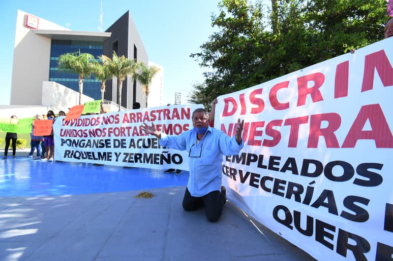 Con gritos, reclamos y hasta de rodillas, empleados de bares, cantinas y cervecerías del poniente de Torreón exigieron en la Plaza Mayor que se les permita regresar a sus actividades comerciales. (FERNANDO COMPEÁN)