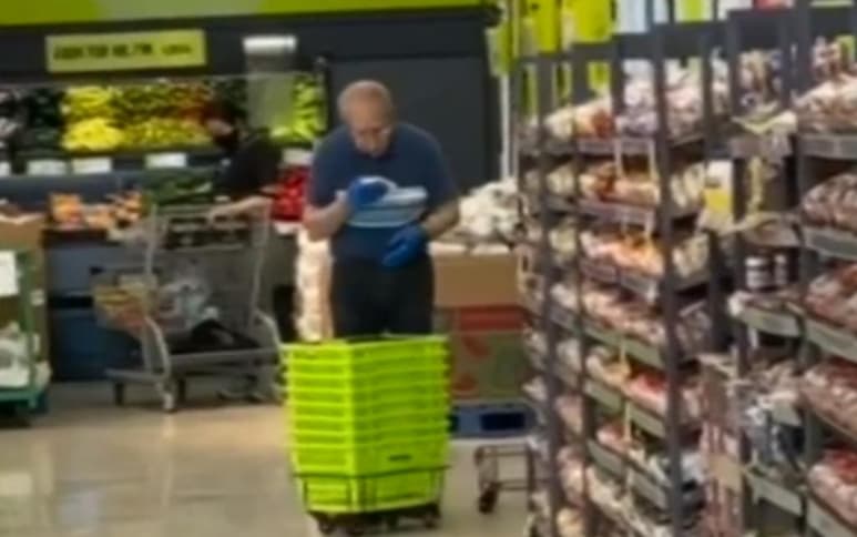 En las imágenes se aprecia al hombre usar su saliva para limpiar las canastas con un paño (CAPTURA)