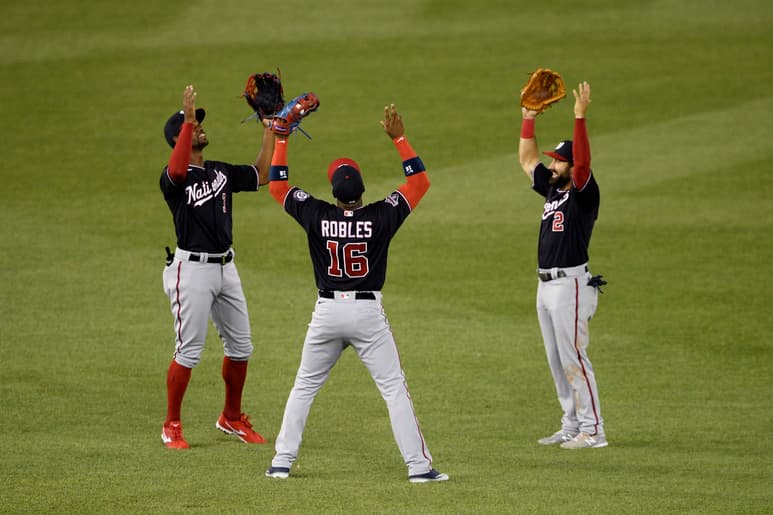 Los jardineros de los Nacionales de Washington Michael Taylor (i), Víctor Robles y Adam Eaton (d) celebran luego de la victoria ante Toronto. (AP)