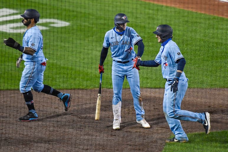 Danny Jansen (d) choca la mano con Cavan Biggio, luego de conectar un jonrón con la casa llena en la sexta entrada. (AP)