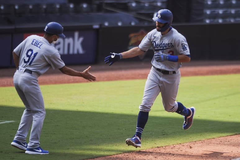 El coach de tercera Dino Ebel felicita a Chris Taylor, quien pegó un jonrón solitario en la sexta entrada. (AP)