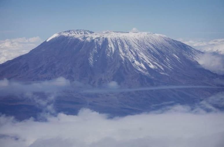 Bomberos, voluntarios e incluso estudiantes universitarios tratan de extinguir un incendio que comenzó el domingo por la noche en un campo base para vías de ascenso al Kilimanjaro, la montaña más alta de África, en el norte de Tanzania. (ESPECIAL)