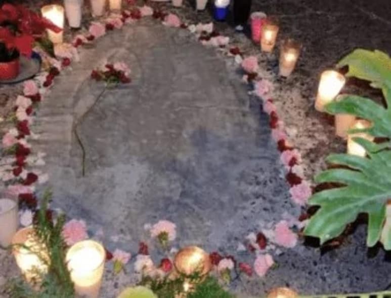En la calle San Marqueña de la colonia Benito Juárez, en Nezahualcóyotl, vecinos colocaron velas, flores y una cinta amarilla en un bache en donde, aseguran, se formó la silueta de la Virgen de Guadalupe luego de que éste fuera reparado. (Especial)