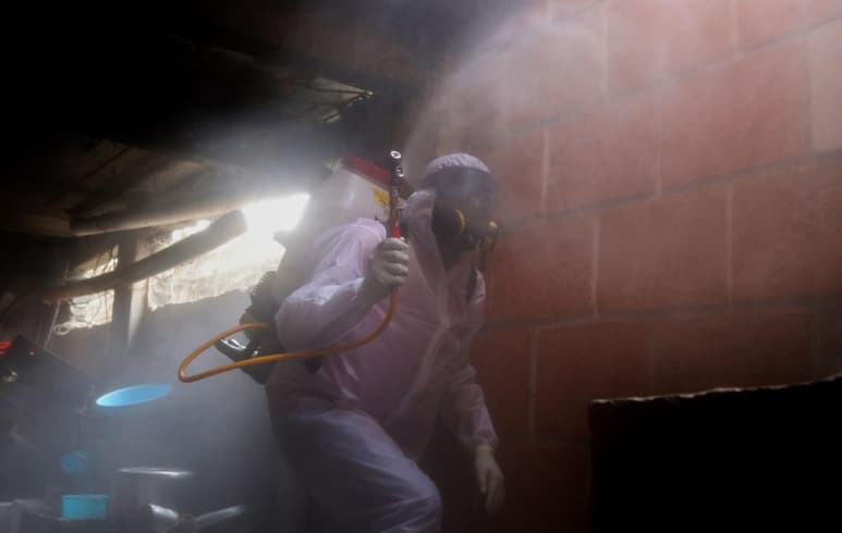 Ataviado con traje de protección, guantes, mascarilla, lentes protectores, desinfectante, gel y una mochila aspersora que pesa más de 30 kilogramos llena de desinfectante, Luis Felipe Gutiérrez se prepara todos los días para trabajar en las brigadas de sanitización de domicilios en Ciudad de México, tras haber superado él mismo la COVID-19. (EFE)