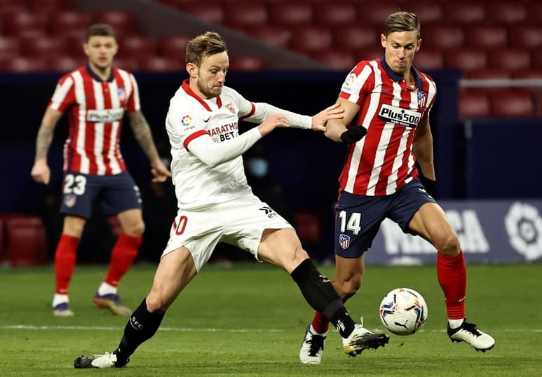 Atlético de Madrid derrotó 2-0 al Sevilla y con dos juegos menos, tiene 4 puntos de ventaja sobre Real Madrid. (AP)