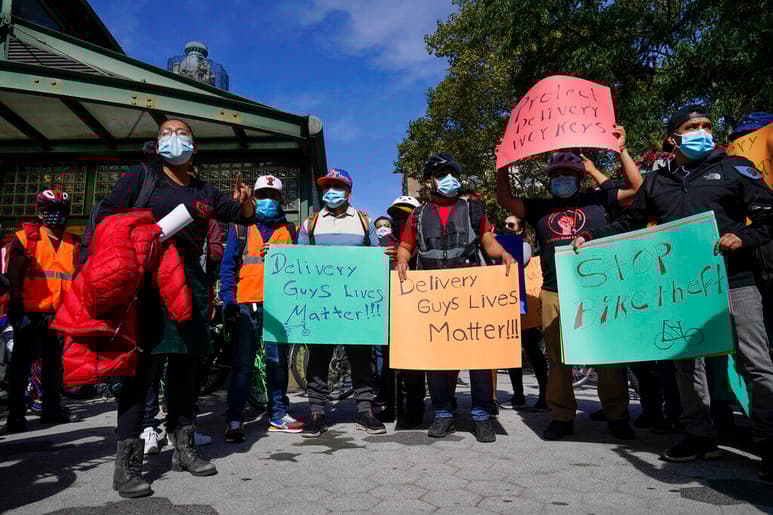 En esta fotografía de archivo del jueves 15 de octubre de 2020, trabajadores de reparto de bicicletas de restaurantes protestan para exigir más protección durante una ola de robos de sus bicicletas eléctricas en Nueva York. Muchos trabajadores latinos de restaurantes en la ciudad de Nueva York celebraron el hecho de que ahora se les permite vacunarse contra el COVID-19 el miércoles 3 de febrero de 2021. (AP Foto/Frank Franklin II, Archivo)