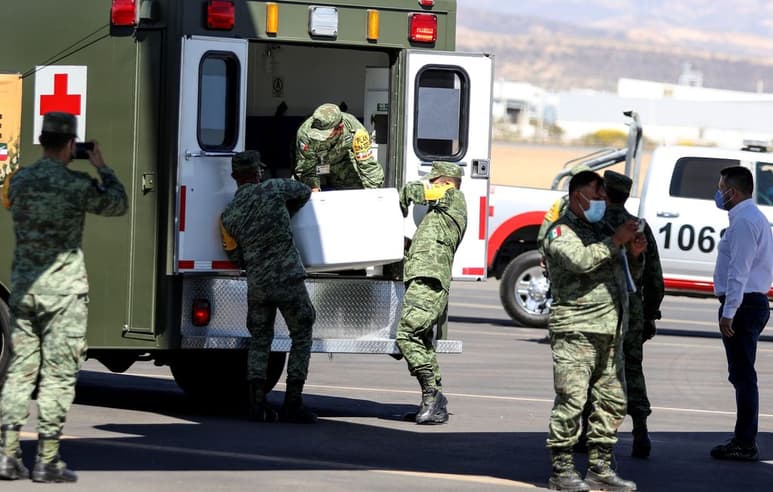 Miembros del Ejército Mexicano descargan contenedores con vacunas de AstraZeneca contra la COVID-19 ayer, en el aeropuerto Internacional de Guanajuato.