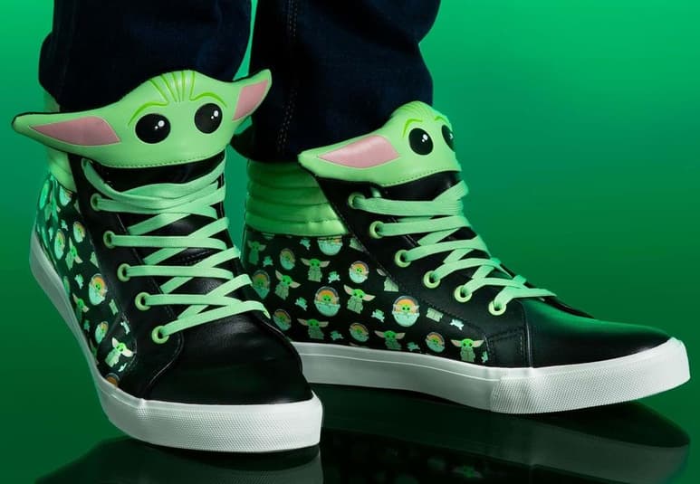 Los tenis son de color negro y sobre ellos corre un estampado de Grugu en diferentes poses, y hasta una rana. (FUN.COM)