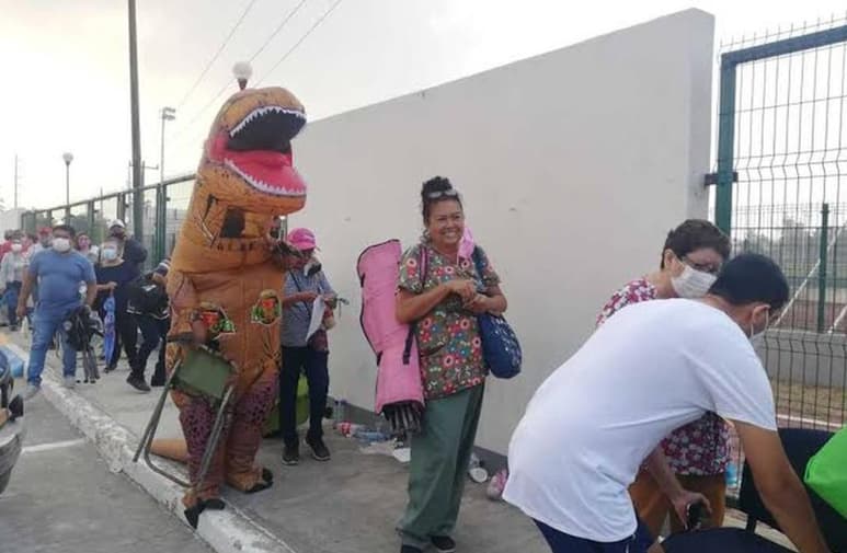 Vistiendo la botarga de dinosaurio, el joven acompañó a su madre en la fila para recibir la vacuna contra el COVID-19 (ESPECIAL)