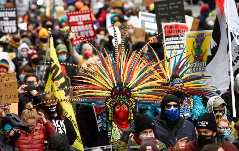 Vestidos con plumas, cintas y atuendos de colores, los Kalpulli Yaocenoxtli se conjuraron este lunes delante de la sede del juicio contra Derek Chauvin, el expolicía acusado de matar al afroamericano George Floyd, para pedir el fin de la brutalidad contra las minorías en EUA. (EFE)