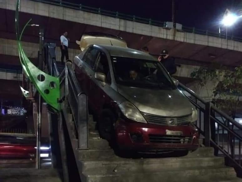 El taxi quedó atorado entre las escaleras cuando intentaba salir del puente peatonal de la calle Morelos, sobre Periférico, en la alcaldía de Naucalpan (ESPECIAL)