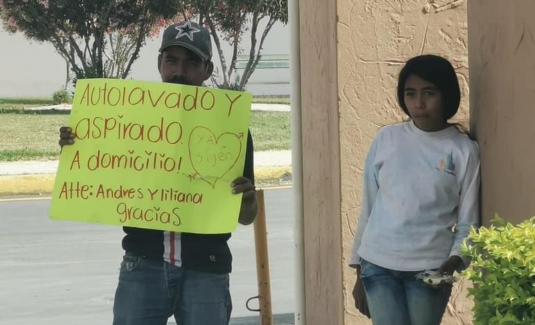 Con una pancarta a las afueras de una nevería de Residencial Senderos, padre e hija ofrecen sus servicios de autolavado (FACEBOOK)