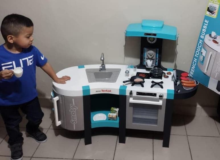 La fotografía del pequeño junto a su cocina de juguete ha cautivado a internautas en redes sociales (FACEBOOK)