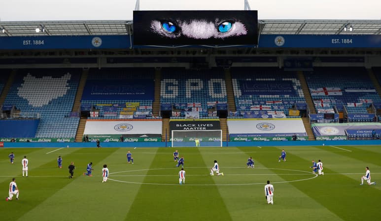 Futbolistas apoyan una rodilla en el césped para manifestarse contra el racismo, antes de un partido entre Leicester City y Crystal Palace.