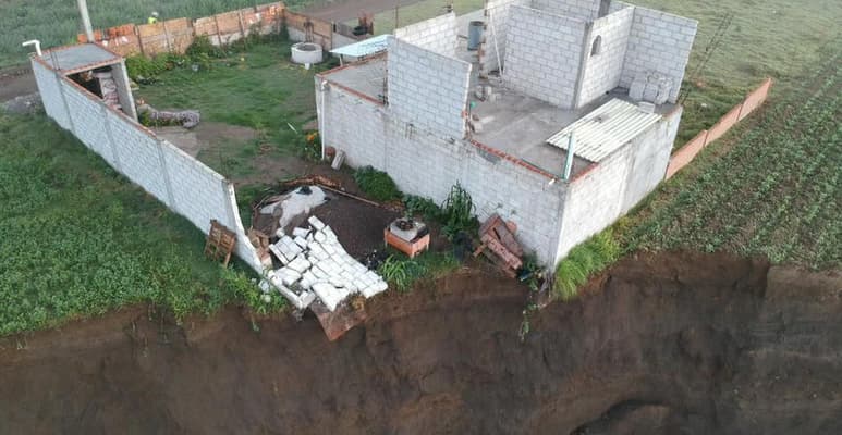 Tras seis días pendiendo del socavón de Puebla, la propiedad que se encontraba a la orilla de la falla geográfica cayó durante la madrugada de este sábado. (Especial)