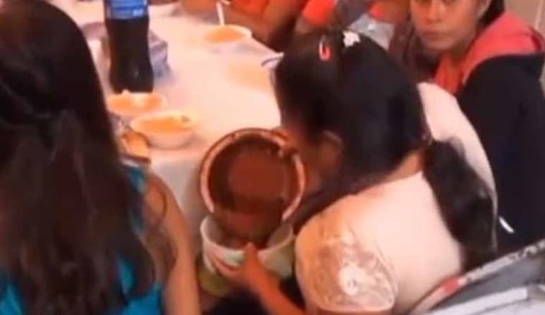 En un 'tupper' la mujer vació la comida que le habían servido, lo que llamó la atención de la persona que grababa (CAPTURA)