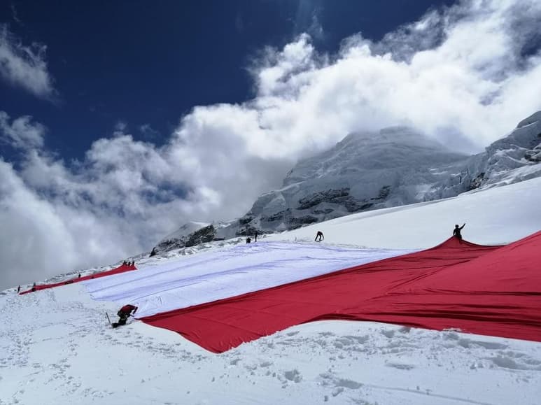 Una bandera peruana gigante de 4,000 metros cuadrados lució sus colores rojo y blanco sobre el Huascarán, la montaña más alta de Perú, para conmemorar el bicentenario de la independencia del país, que se celebrará este 28 julio. (EFE)