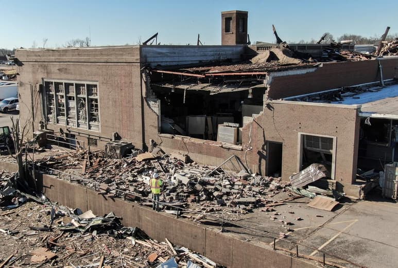 Personal de rescate escarbaba el domingo entre casas y negocios en ruinas tras el paso de un tornado en el estado de Kentucky que arrasó con las construcciones, incluyendo una fábrica de velas que estaba llena de empleados del turno nocturno cuando se vio arrasada. El gobernador advirtió que el número de muertos debido al tornado podría superar los 100. (ARCHIVO)