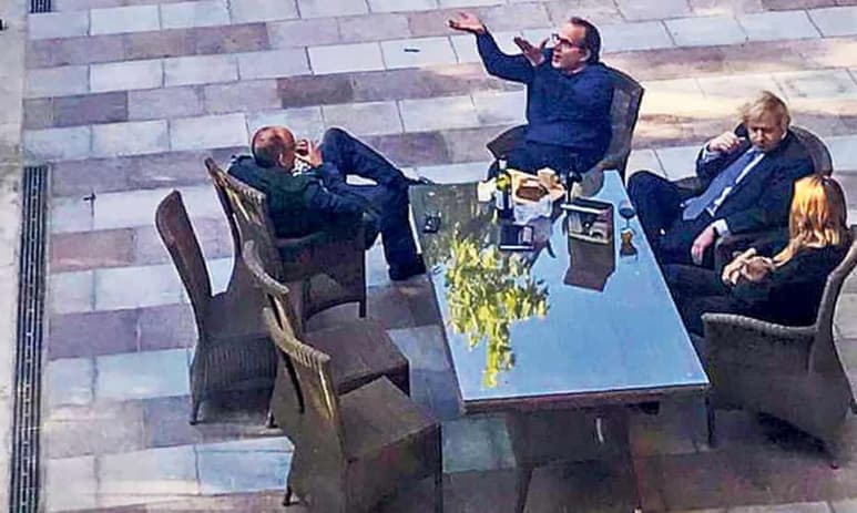 La crisis política que atraviesa el primer ministro británico, Boris Johnson, se agravó este lunes al emerger una fotografía de mayo de 2020, en pleno confinamiento contra la pandemia, en la que aparece bebiendo vino en el jardín de Downing Street con su esposa y varios colaboradores. (ARCHIVO)