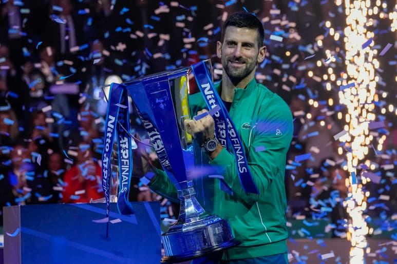 Novak Djokovic carga el trofeo de campeón de la Copa de Maestros de la ATP tras derrotar a Jannik Sinner en la final, el domingo 19 de noviembre de 2023, en Turín. (AP Foto/Antonio Calanni)