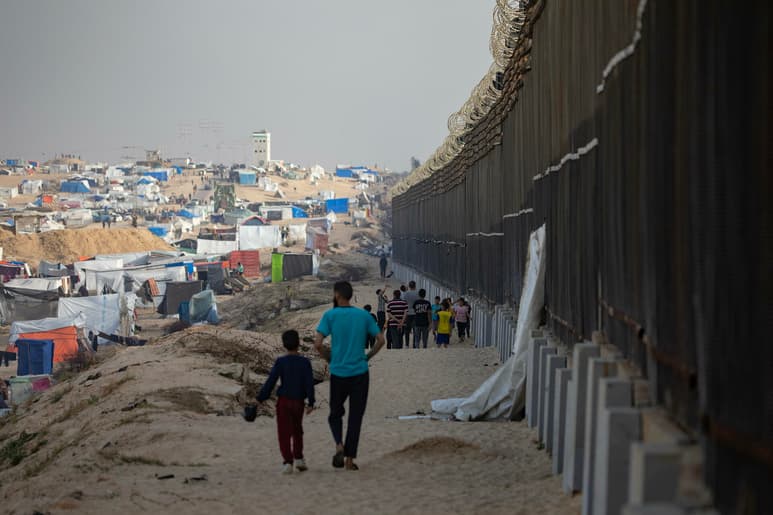 Palestinos desplazados caminan cerca del muro con Egipto en Rafah, ciudad de Gaza. (ARCHIVO)