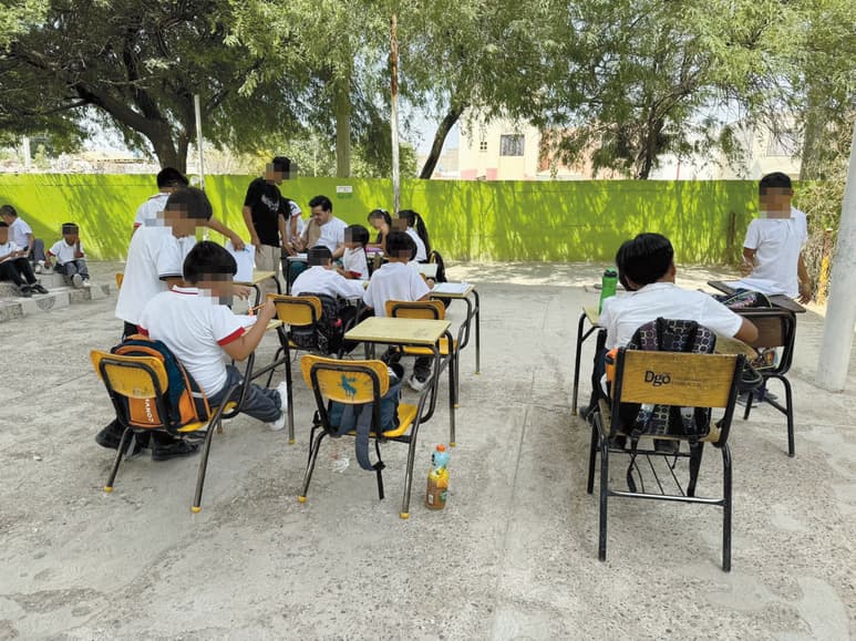 Debido a que no se ha renovado el cableado eléctrico para que puedan funcionar los sistemas de aire, estudiantes de la primaria Leona Vicario, esta semana tomaron las clases en el patio escolar. (Angélica Sandoval)