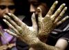 Una mujer pakistaní muestra sus manos decoradas al fin de la celebración del mes santo de Ramadan. Musulmanes alrededor del mundo festejan el mes santo de Ramadán absteniéndose de comer y beber durante el mismo.