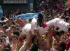 Miles de temerarios se lanzaron a las calles de esta ciudad española para correr delante de una manada de toros, celebrando el primer encierro de los sanfermines del 2003.