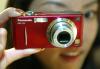 Una mujer muestra la nueva cámara de Panasonic Dmc-Fx5, esta cámara es la primera que cuenta con un zoom óptico de 3 x equipado con un estabilizador de imagen.