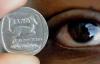 Un cajero mira un rand, la moneda local de Sudáfrica, la cual ha tenido que enfrentar en una fuerte devaluación frente al dólar..