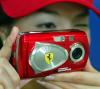Una empleada de Olympus Corporation muestra la nueva cámara de la compañía, Ferrari Digital 2003, la primera cámara digital del mundo patentada por una marca de automóviles, la Ferrari. La edición de la cámara será limitada con 1000 cámaras con lo que se pretende celebrar el patrocinio de la escudería de autos en el Gran Premio de Japón.