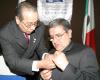 Javier Ruiz Rodríguez le coloca el botoncillo de presidente saliente a Jesús Hernández Aristegui.