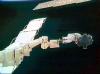 El astronauta Stephen Robinson, montado en el extremo de un brazo robótico de 50 metros de largo, retiró suavemente dos trozos de fieltro de relleno que sobresalían entre las losas de protección térmica del transbordador 'Discovery'.