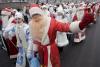 Varios hombres disfrazados de Santa  y mujeres vestidas de 'Doncella de la Nieve'  participan en un desfile por las principales calles de Minsk Bielorrusia.