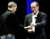 El consejero delegado de Intel Paul Otellini  le entrega al director general y cofundador de Apple Steve Jobs un chip simbólico durante el discurso de apertura de Jobs de la Macworld Expo 2008 en San Francisco, California.