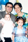 El bautizado con sus padrinos Carlos Flores y Usua Belausteguigoitia de Martínez.