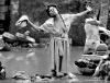 Mujer que intenta lavar su ropa en un río lleno de lodo en Goinaives.
