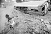 Una niña salta de la puerta de un bus escolar abandonado en Gonaives.