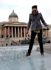 Una turista camina por una de las fuentes heladas de la plaza de Trafalgar en Londres, Inglaterra.